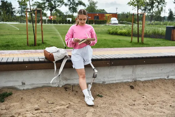 A young woman in vibrant outfit embraces an calm lifestyle outdoors, reading while enjoying nature. — Stock Photo