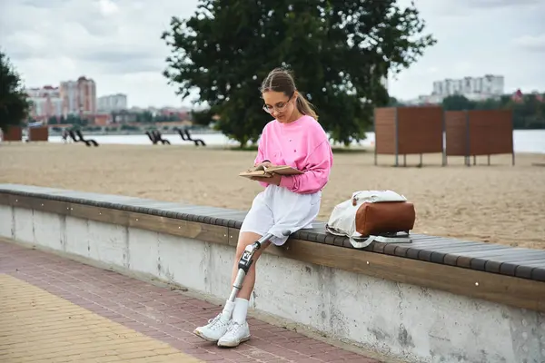 A young woman in sportswear reads peacefully by the water, embracing nature and her active lifestyle. — Stock Photo