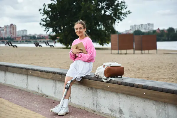 A determined young woman with a prosthetic leg relaxes outside, enjoying her day — Stock Photo