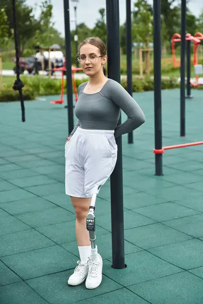 A determined young woman with a prosthetic leg exercises outdoors, embracing an active lifestyle in sportswear. — Stock Photo