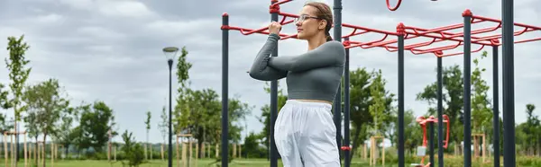 A determined young woman exercising outdoors in fitness park — Stock Photo