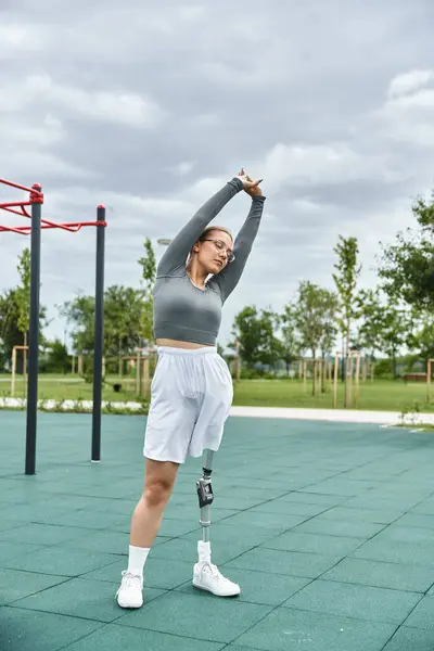 A young woman in sportswear stretches outdoors, showcasing resilience and dedication to fitness. — Stock Photo