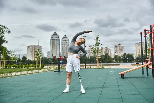 A determined young woman stretches outdoors, showcasing her strength and resilience while exercising. — Stock Photo