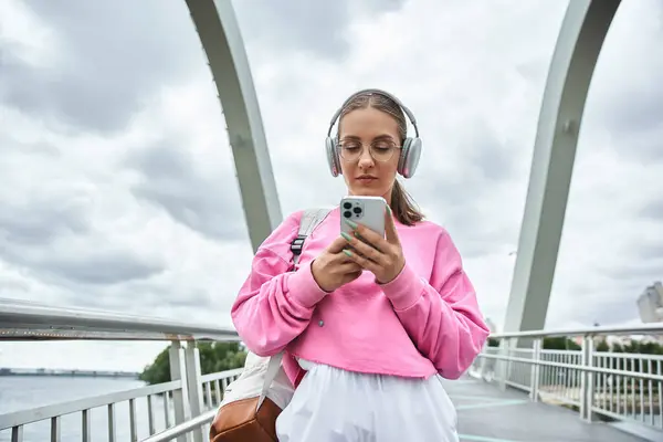 Молода жінка використовує смартфон і слухає музику в навушниках — Stock Photo