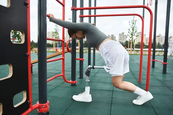 Uma jovem mulher com uma perna protética se envolve em um treino ao ar livre, demonstrando força e determinação. — Fotografia de Stock