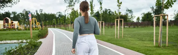 A spirited young woman exercises outdoors, embracing the vibrant atmosphere of the park. — Stock Photo