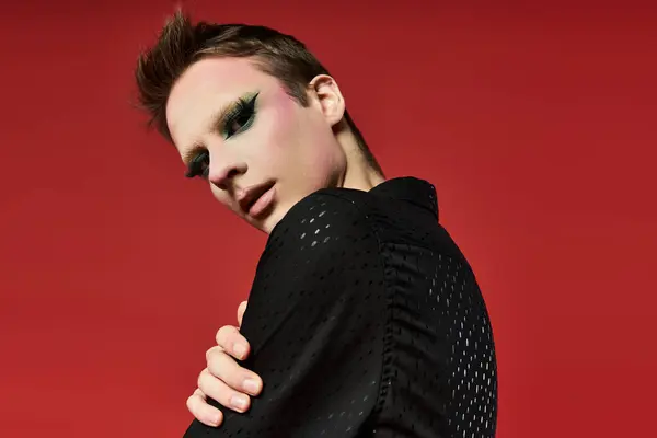 A vibrant drag artist showcases bold style and expressive makeup in a striking pose. — Stock Photo