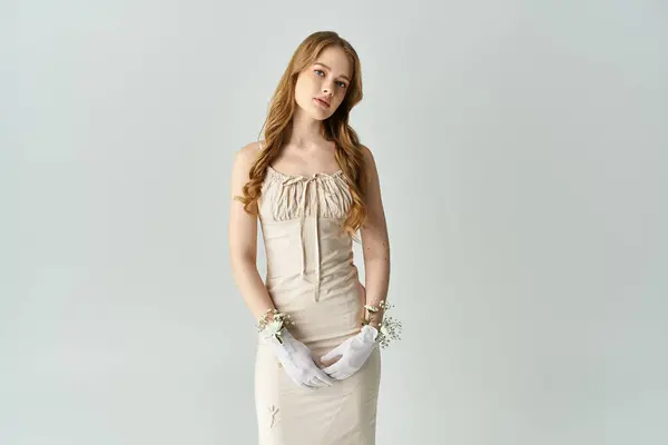 A serene moment with a young woman adorned in a lovely dress and flowers. — Stock Photo