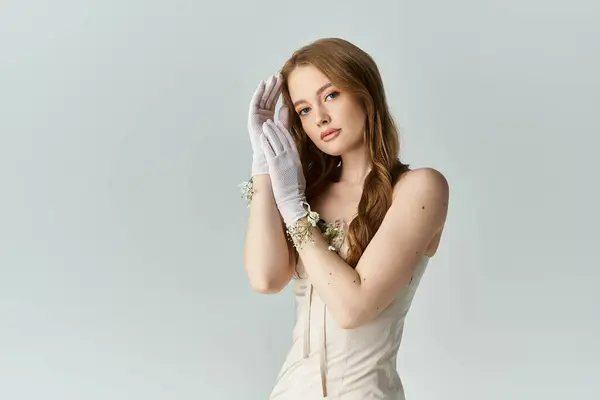 A graceful young woman adorns her hands with delicate flowers. — Stock Photo