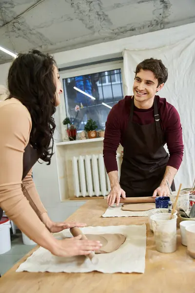 Un couple façonne joyeusement l'argile dans leur atelier de poterie lumineuse. — Photo de stock