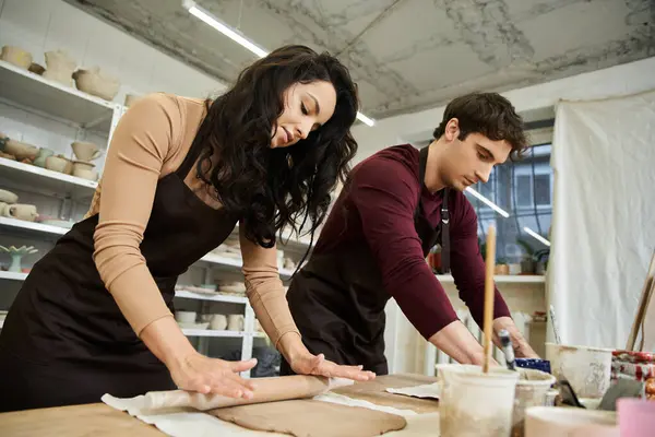 A couple joyfully shapes clay at their pottery workbench. — Stock Photo