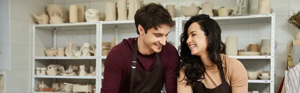 A couple joyfully shaping clay together in a bright pottery studio. — Stock Photo