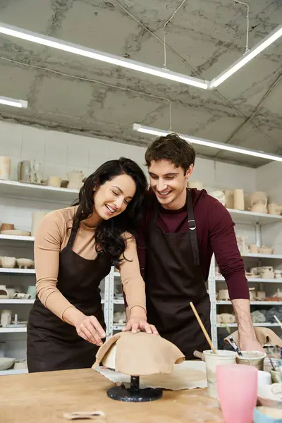 A loving couple shapes clay during a pottery session in a contemporary studio. — Stock Photo