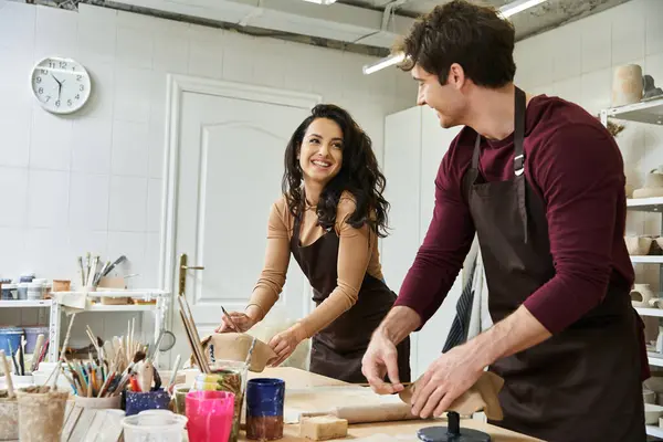 A couple joyfully crafts pottery together in a contemporary studio. — Stock Photo