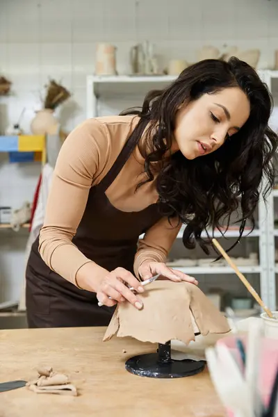 Devoted brunette woman making pottery in well lit studio. — Stock Photo