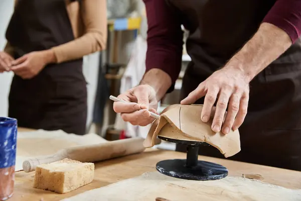 A couple shares a joyful moment shaping clay together. — Stock Photo