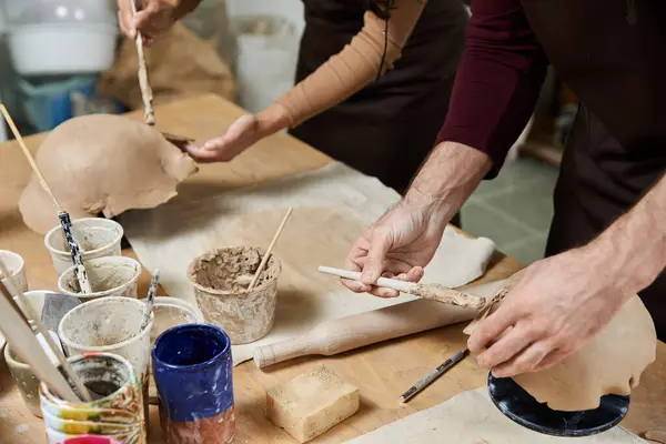 Due artisti modellano argilla mentre si godono un momento creativo nel loro studio. — Foto stock