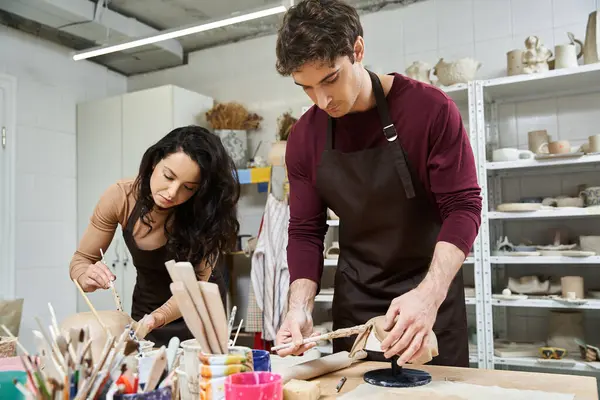 Two artists share a moment making pottery together in a contemporary workspace. — Stock Photo