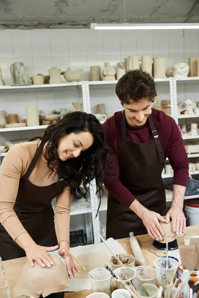 A couple joyfully molds clay in a bright, contemporary pottery studio. — Stock Photo