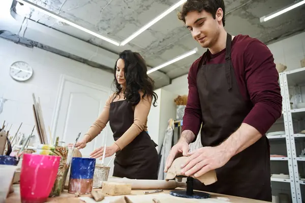 Couple joyfully shaping clay in a contemporary pottery studio. — Stock Photo