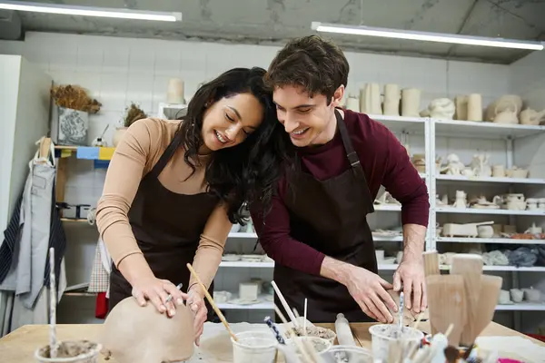 A loving couple crafts unique pottery pieces in a bright studio. — Stock Photo