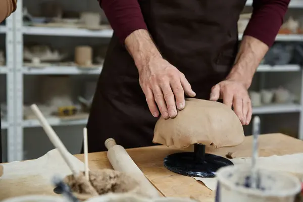 Man in black apron making pottery. — Stock Photo