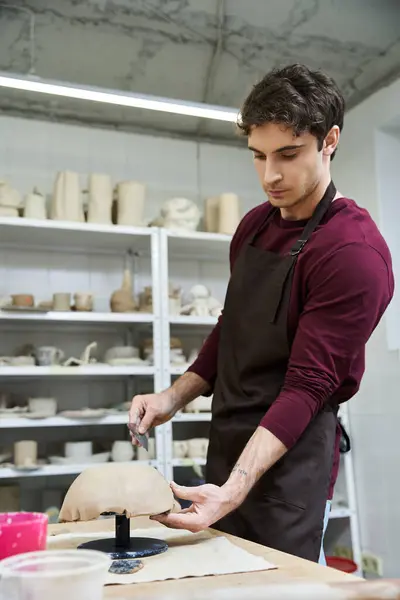 Stylish man in apron making pottery. — Stock Photo
