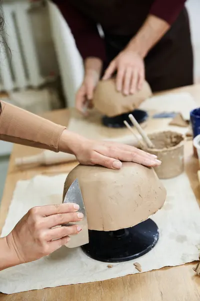 Una pareja disfruta de la elaboración de cerámica con sonrisas en un estudio soleado. - foto de stock