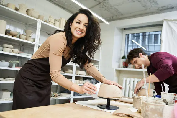 A joyful couple molds clay while sharing smiles in a creative space. — Stock Photo