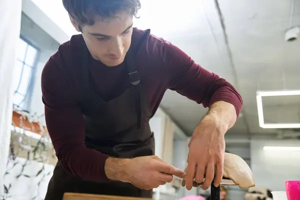 Dedicated appealing man with dark hair making pottery. — Stock Photo