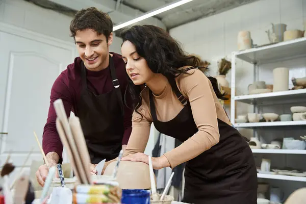 A couple enjoys crafting pottery side by side in a bright workspace. — Stock Photo
