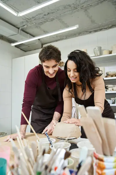 Loving partners shape clay in a spacious, artistic pottery studio. — Stock Photo