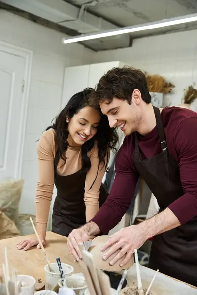 Two people share smiles while shaping clay in a creative space. — Stock Photo