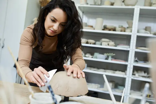 Appealing woman with dark hair making pottery. — Stock Photo