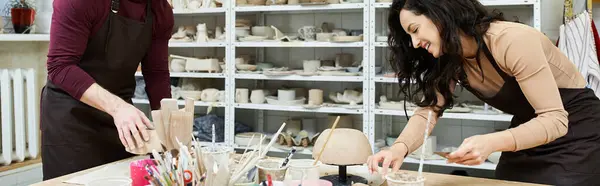 A couple shares laughter while shaping clay in a bright studio. — Stock Photo