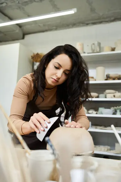 Young good looking woman with dark hair making pottery. — Stock Photo