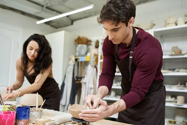 A loving couple enjoys making clay pottery in a contemporary workspace. — Stock Photo