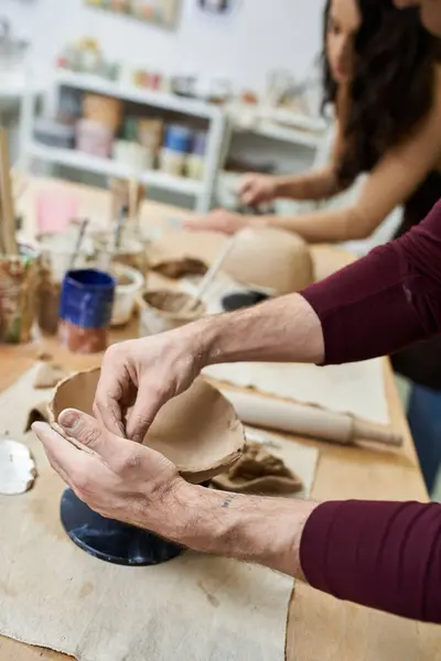 A couple joyfully shapes clay in a modern pottery studio. — Stock Photo