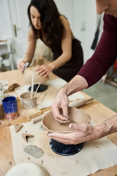 Un couple crée joyeusement des poteries ensemble dans un studio moderne. — Photo de stock