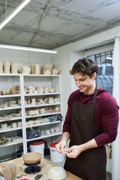 Trabalhador homem alegre com avental fazendo cerâmica. — Stock Photo