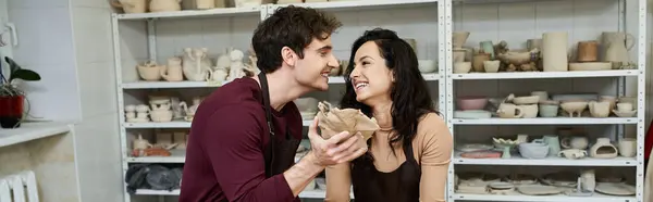 Um casal alegremente artesanato cerâmica, compartilhando um momento terno em um estúdio brilhante. — Fotografia de Stock