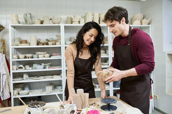 A loving couple joyfully molds clay together at their pottery studio. — Stock Photo