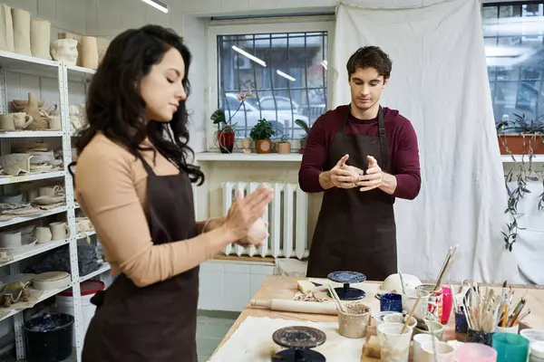 A couple joyfully shapes clay at a pottery workspace. — Stock Photo