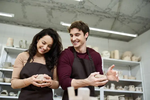 Una pareja moldea apasionadamente la arcilla, creando arte juntos en un taller contemporáneo. — Stock Photo