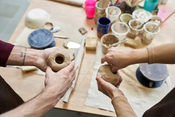 A couple joyfully molds clay into art in their vibrant pottery studio. — Stock Photo