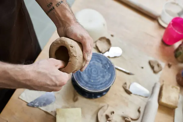 Cheerful talented man in apron making some pottery in studio. — Stock Photo
