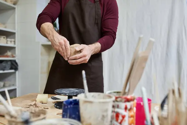 Sophisticated dedicated man in apron making some pottery in studio. — Stock Photo