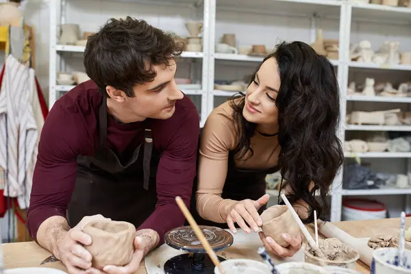 A loving couple crafts pottery while sharing smiles in a vibrant studio. — Stock Photo