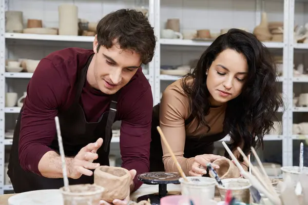 A couple joyfully shapes clay in a contemporary pottery studio. — Stock Photo