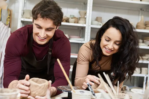 Una coppia amorevole plasma argilla, condividendo sorrisi e creatività nel loro studio di ceramica. — Foto stock